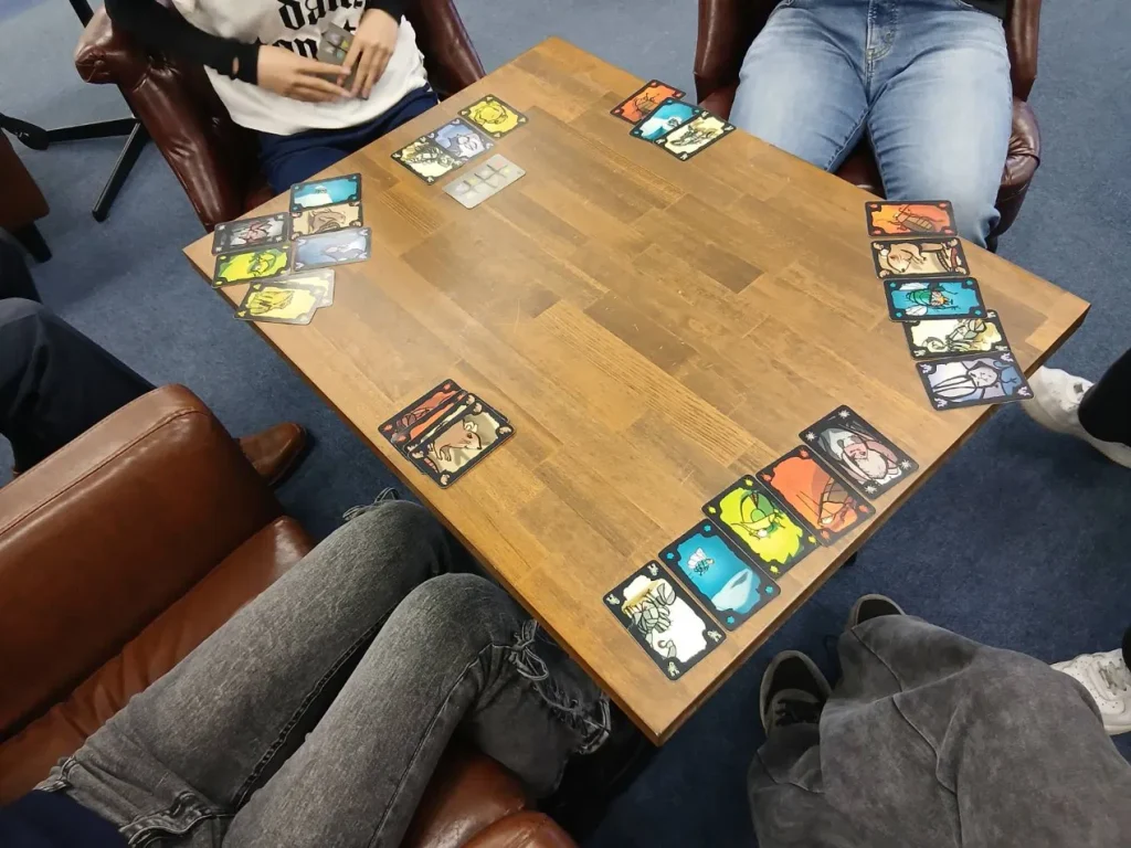 校舎で生徒たちがボードゲーム（ごきぶりポーカー）を楽しんでいる様子